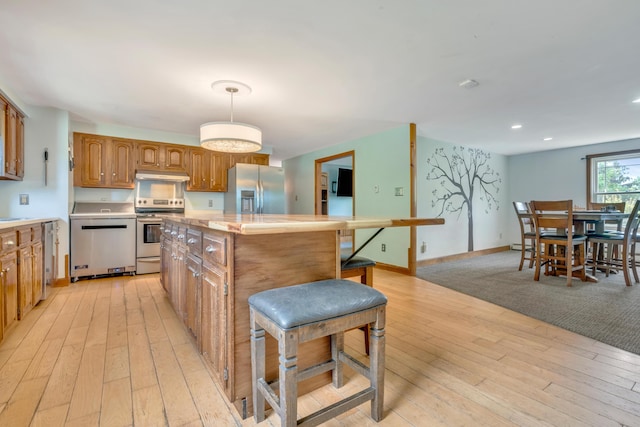 116 Point Rd, Acton, ME 04001 - kitchen featuring appliances with stainless steel finishes, under cabinet range hood, a kitchen island, light countertops, and light wood-style floors