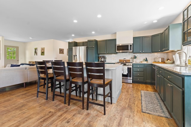 18 Fox Meade Ln, Searsmont, ME 04973 - kitchen with stainless steel appliances, a sink, a kitchen island, backsplash, and light stone counters