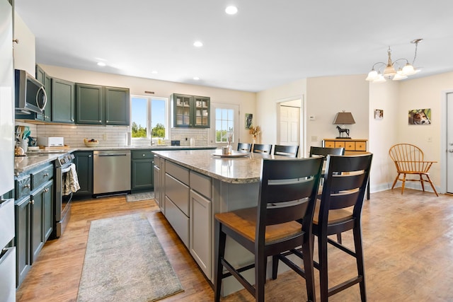 18 Fox Meade Ln, Searsmont, ME 04973 - kitchen featuring appliances with stainless steel finishes, green cabinets, light wood-style flooring, a breakfast bar, and recessed lighting