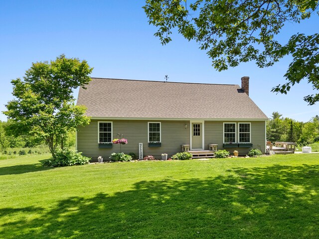 18 Fox Meade Ln, Searsmont, ME 04973 - back of house featuring a yard, a chimney, and a shingled roof