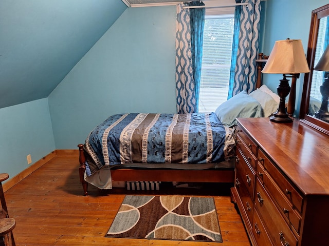 433 Hudson Rd, Corinth, ME 04427 - bedroom with wood-type flooring, vaulted ceiling, multiple windows, and baseboards