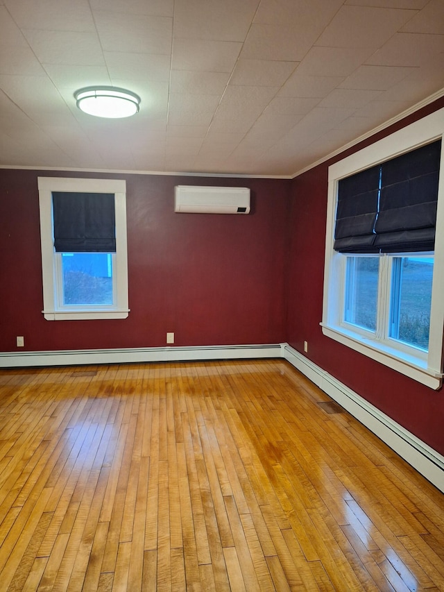 433 Hudson Rd, Corinth, ME 04427 - spare room featuring a wall mounted air conditioner, wood-type flooring, a baseboard radiator, and baseboards