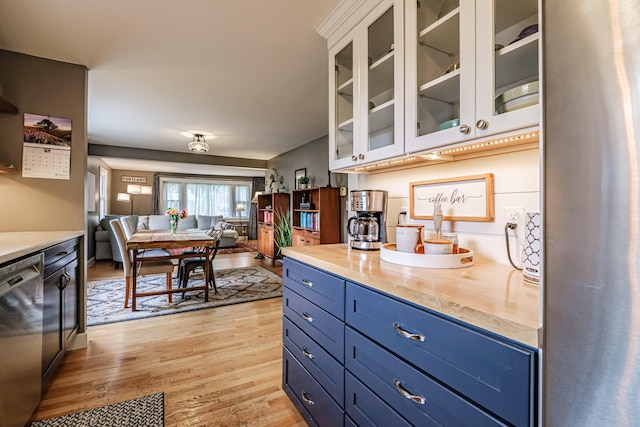 115 Caleb St, Portland, ME 04102 - kitchen with blue cabinetry, stainless steel dishwasher, light wood finished floors, open floor plan, and butcher block countertops