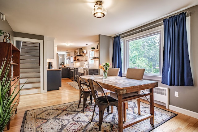 115 Caleb St, Portland, ME 04102 - dining area with light wood-style flooring, radiator, stairs, and baseboards