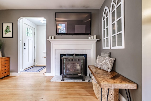 115 Caleb St, Portland, ME 04102 - living area featuring wood finished floors, baseboards, a wood stove, and arched walkways