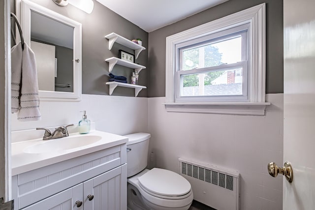 115 Caleb St, Portland, ME 04102 - half bathroom with radiator, toilet, vanity, and tile walls