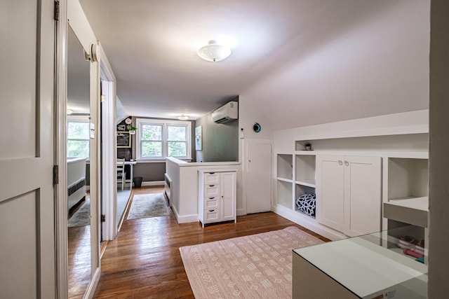 115 Caleb St, Portland, ME 04102 - interior space featuring dark wood-style floors, a wall mounted AC, vaulted ceiling, and baseboards