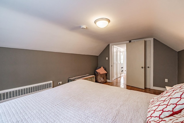 115 Caleb St, Portland, ME 04102 - bedroom featuring wood finished floors, radiator heating unit, vaulted ceiling, and baseboards