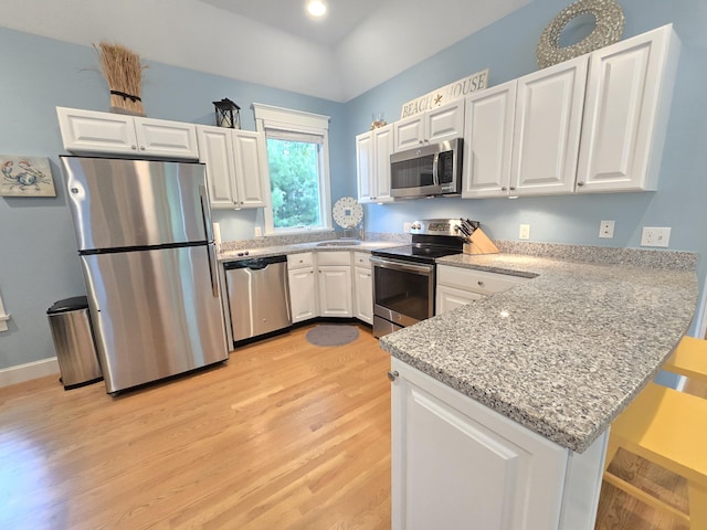 1 Old County Rd Unit 600, Wells, ME 04090 - kitchen with appliances with stainless steel finishes, a peninsula, light wood-type flooring, white cabinetry, and a sink