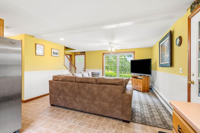 578 Little River Rd, Lebanon, ME 04027 - living room with a wainscoted wall, baseboard heating, stairway, and a ceiling fan