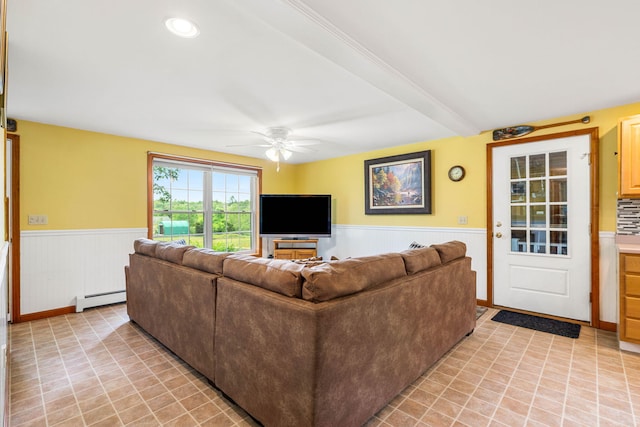 578 Little River Rd, Lebanon, ME 04027 - living room with a baseboard heating unit, a wainscoted wall, a ceiling fan, and light tile patterned floors