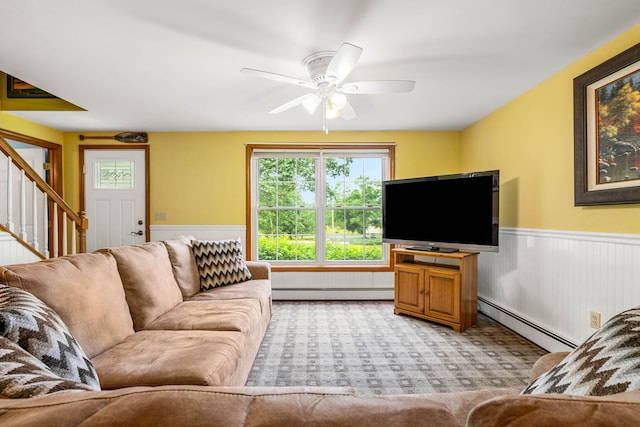 578 Little River Rd, Lebanon, ME 04027 - living room featuring a baseboard radiator, stairway, wainscoting, a ceiling fan, and light colored carpet