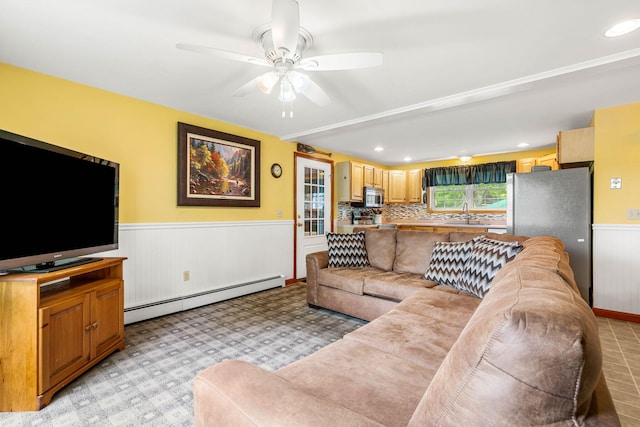 578 Little River Rd, Lebanon, ME 04027 - living area with a baseboard radiator, a wainscoted wall, ceiling fan, recessed lighting, and light colored carpet