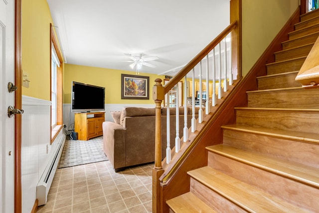 578 Little River Rd, Lebanon, ME 04027 - staircase featuring baseboard heating, ceiling fan, and a wainscoted wall