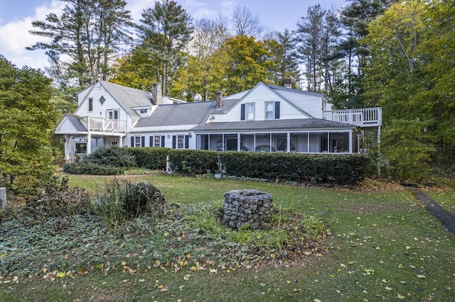 9 Dry Point Dr, Rome, ME 04963 - view of front of house with a chimney, a sunroom, a front yard, a balcony, and view of scattered trees