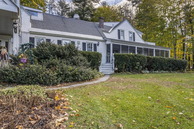 9 Dry Point Dr, Rome, ME 04963 - view of front of house featuring a sunroom, a chimney, a front yard, and a shingled roof