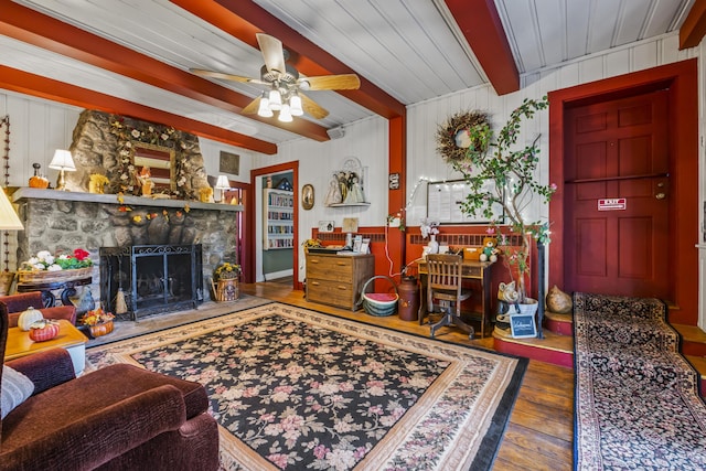 9 Dry Point Dr, Rome, ME 04963 - living area with wood-type flooring, beam ceiling, a fireplace, and a ceiling fan