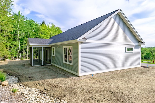 19 Efficiency Way, Bridgton, ME 04009 - view of side of property with a shingled roof, a sunroom, and a patio
