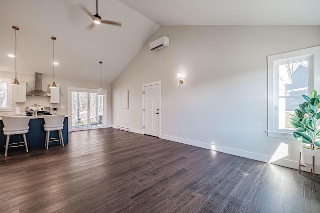 19 Efficiency Way, Bridgton, ME 04009 - unfurnished living room featuring ceiling fan, a baseboard radiator, dark wood-type flooring, high vaulted ceiling, and plenty of natural light