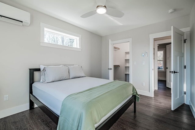 19 Efficiency Way, Bridgton, ME 04009 - bedroom with a wall mounted air conditioner, multiple windows, dark wood-type flooring, and baseboards