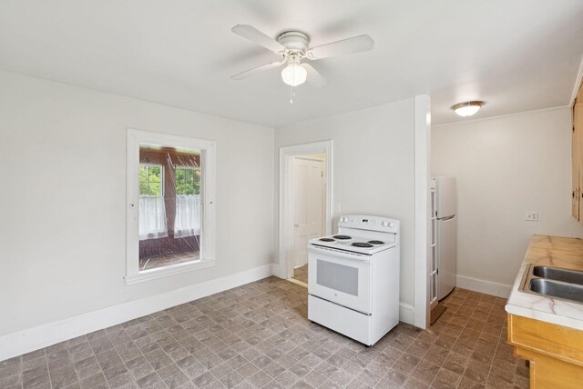20 Green St, Winthrop, ME 04364 - kitchen with white appliances, light countertops, ceiling fan, baseboards, and a sink