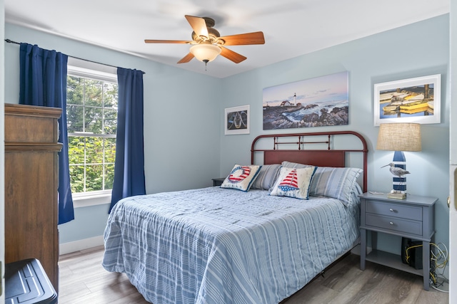 1139 Post Rd Unit 102, Wells, ME 04090 - bedroom with wood finished floors, a ceiling fan, and baseboards