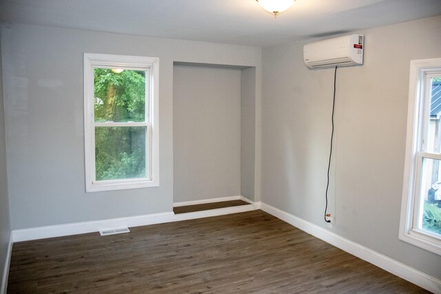 2 Watson Ave, Houlton, ME 04730 - unfurnished room with a wall mounted air conditioner, dark wood-style floors, and baseboards