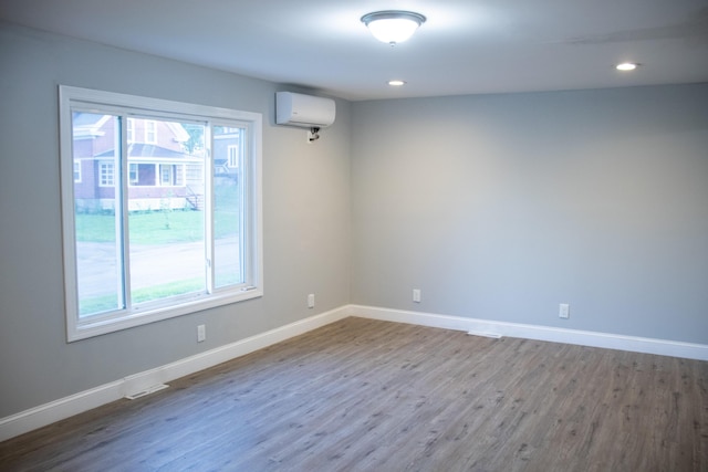 2 Watson Ave, Houlton, ME 04730 - empty room with wood finished floors, baseboards, recessed lighting, and an AC wall unit