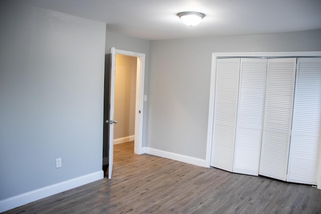 2 Watson Ave, Houlton, ME 04730 - unfurnished bedroom with wood finished floors, baseboards, and a closet