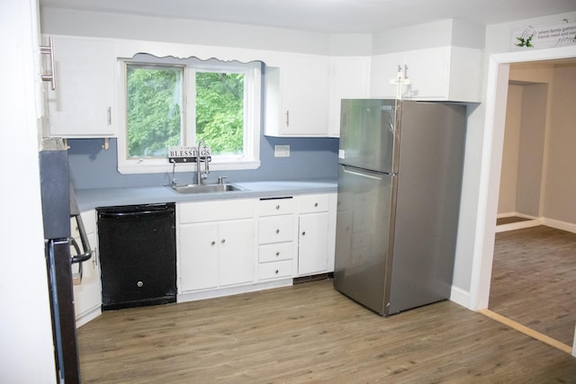 2 Watson Ave, Houlton, ME 04730 - kitchen featuring freestanding refrigerator, black dishwasher, a sink, white cabinetry, and light countertops