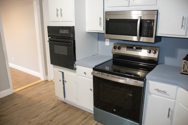 2 Watson Ave, Houlton, ME 04730 - kitchen featuring stainless steel appliances, white cabinets, light wood finished floors, baseboards, and light countertops