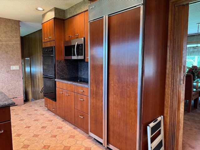 02 Rogers St, Houlton, ME 04730 - kitchen featuring stainless steel microwave, paneled refrigerator, brown cabinetry, heating unit, and backsplash