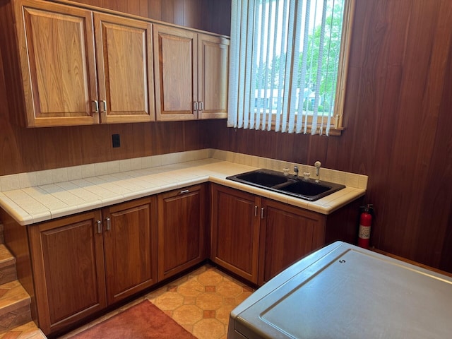 02 Rogers St, Houlton, ME 04730 - kitchen with washer / clothes dryer, a sink, and brown cabinetry