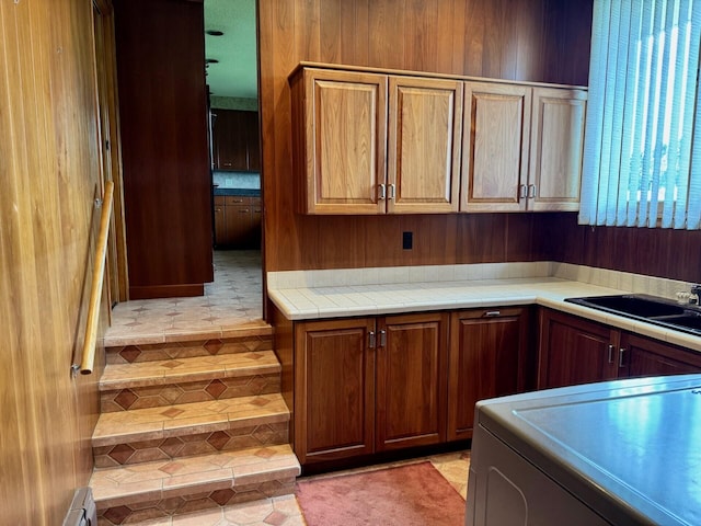 02 Rogers St, Houlton, ME 04730 - kitchen with a sink, washer / dryer, light tile patterned floors, and tile counters