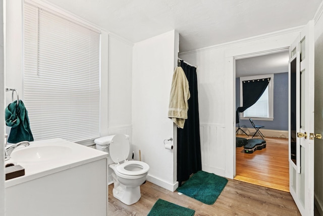 82 Winter St, Portland, ME 04102 - bathroom with wood finished floors, toilet, vanity, and wainscoting