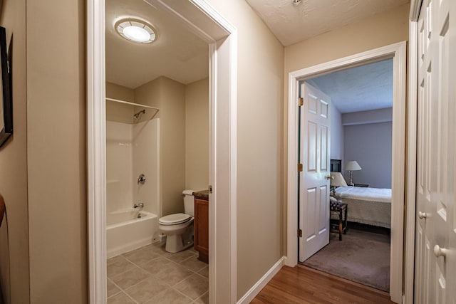 170 E Grand Ave Unit 1, Old Orchard Beach, ME 04064 - ensuite bathroom with shower / washtub combination, toilet, vanity, wood finished floors, and baseboards