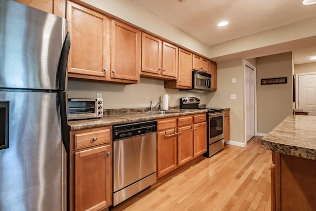 170 E Grand Ave Unit 1, Old Orchard Beach, ME 04064 - kitchen with stainless steel appliances, a sink, light wood-style floors, recessed lighting, and dark countertops
