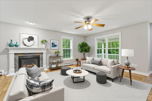 8 Rileys Run, Berwick, ME 03901 - living room featuring a ceiling fan, a baseboard heating unit, a high end fireplace, baseboards, and wood finished floors