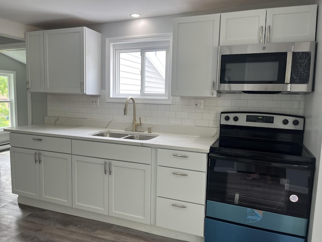 6 Hidden Ave, Livermore Falls, ME 04254 - kitchen with stainless steel appliances, a sink, decorative backsplash, dark wood-style flooring, and white cabinets