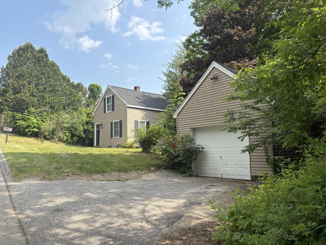 152 Bradman St, Auburn, ME 04210 - view of property exterior with driveway, a garage, a chimney, an outdoor structure, and a yard