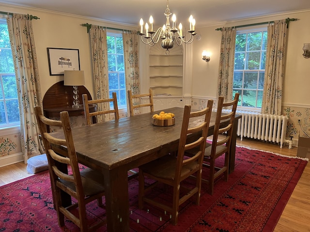 2 Lookout Point Rd, Bar Harbor, ME 04609 - dining room featuring radiator heating unit, a chandelier, wood finished floors, and ornamental molding