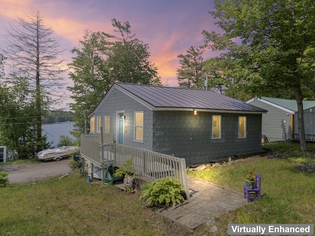 48 E Shore Dr, Greene, ME 04236 - view of front of home featuring a front yard, metal roof, and a water view