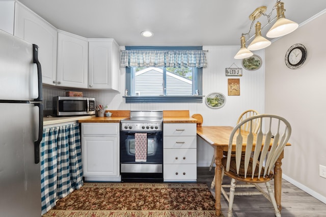 48 E Shore Dr, Greene, ME 04236 - kitchen with appliances with stainless steel finishes, white cabinets, butcher block countertops, baseboards, and dark wood-style flooring
