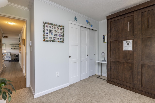 219 E Grand Ave Unit 3C, Old Orchard Beach, ME 04064 - bedroom featuring a closet, crown molding, a textured ceiling, and light colored carpet