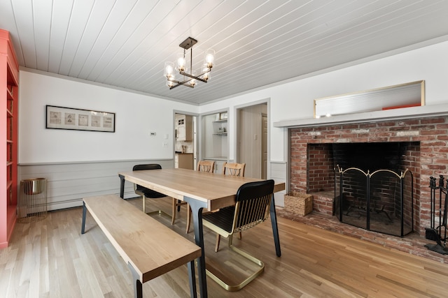 106 Fieldstone Estates Rd, York, ME 03909 - dining area with wooden ceiling, a brick fireplace, wood finished floors, a wainscoted wall, and a chandelier