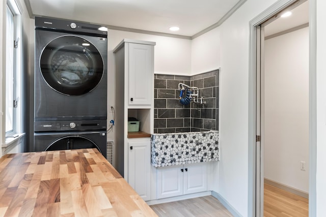 106 Fieldstone Estates Rd, York, ME 03909 - laundry area featuring stacked washer / drying machine, cabinet space, and light wood-style floors