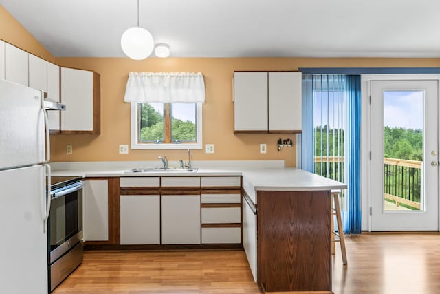 51 Burnham Rd, Saco, ME 04072 - kitchen with freestanding refrigerator, stainless steel electric stove, a peninsula, light wood-style flooring, and a sink