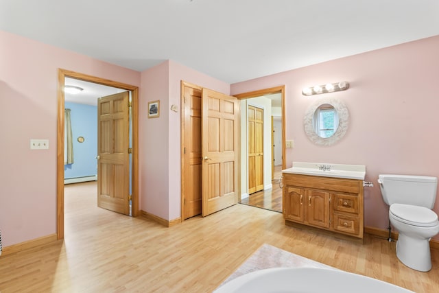 51 Burnham Rd, Saco, ME 04072 - bathroom with wood finished floors, vanity, a baseboard heating unit, toilet, and baseboards