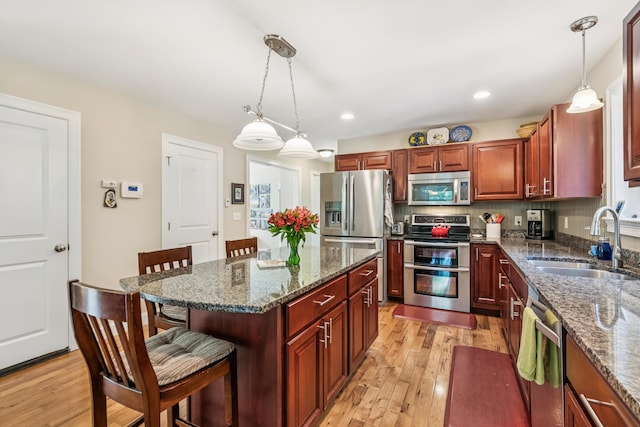 3 Bradfield Way, Kennebunk, ME 04043 - kitchen with stainless steel appliances, a kitchen bar, light wood-style flooring, pendant lighting, and recessed lighting