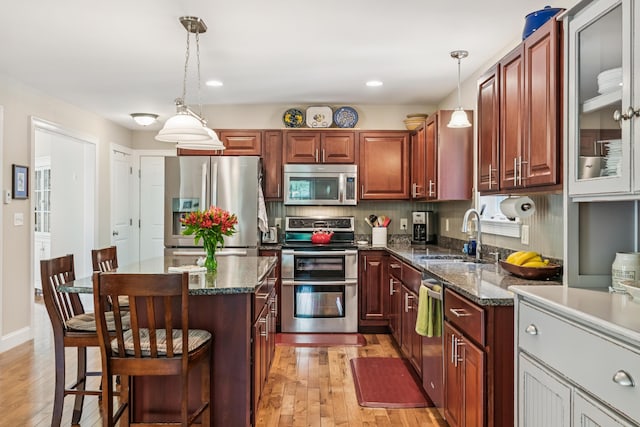 3 Bradfield Way, Kennebunk, ME 04043 - kitchen featuring stainless steel appliances, a kitchen bar, light wood-type flooring, decorative light fixtures, and a kitchen island